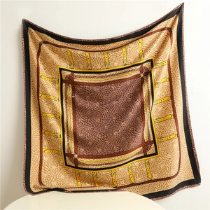 Close-up of retro equestrian print and buckle patterns on a luxury silk twill scarf