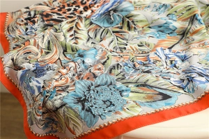 Detail of 90cm silk scarf with leopard print, tropical florals, and orange border