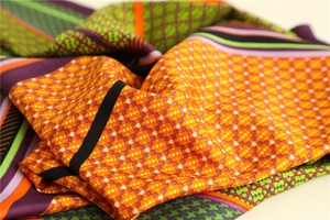 Detailed view of houndstooth silk scarf with vibrant geometric patterns and satin finish