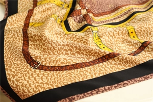 Detailed macro view of twill silk scarf showing vintage belt patterns and fish scale texture