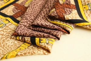 Close-up of silk twill scarf showing intricate fish scale patterns and luxury belt prints