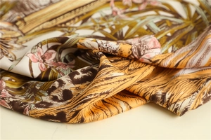 Macro shot of tropical palm leaves and orchid floral print on soft silk square scarf