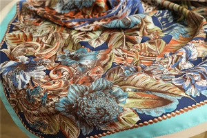 Detail of silk scarf showing tropical leaves and vintage floral prints with soft sheen
