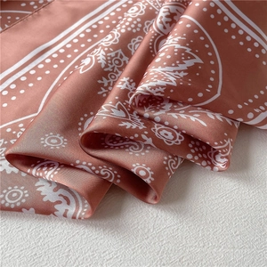 Macro detail of silk-like paisley square scarf in dusty rose with smooth satin texture