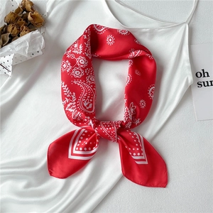 Red paisley silk scarf with white pattern displayed on a white satin camisole top