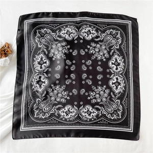 Detailed view of square silk scarf featuring black and white paisley floral patterns