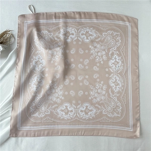 Macro detail of champagne satin square scarf with paisley floral prints and white border