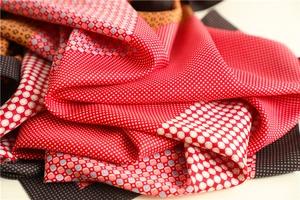Detail of elegant red and brown silk scarf fabric with fine polka dots and geometric patterns