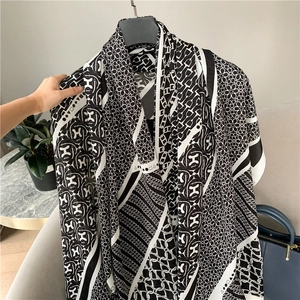 Detail of silk scarf with classic H-pattern and chain motifs in black and white