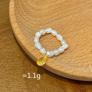 Detailed close-up of a handmade freshwater pearl ring featuring a yellow teardrop gemstone