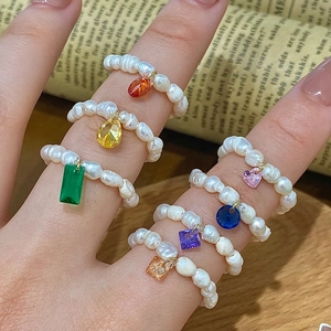 Handmade freshwater pearl ring set with colorful zircon charms on vintage background