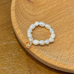 Detailed shot of a beaded freshwater pearl ring featuring a square amber crystal pendant