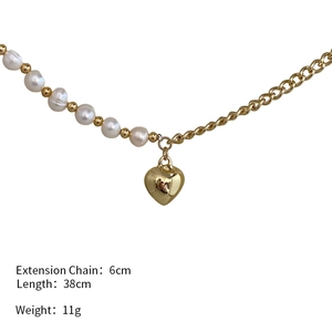 Detail of heart pendant necklace with asymmetrical pearl chain and gold link design