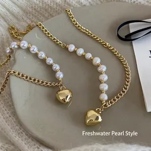 Detailed shot of golden heart pendant with freshwater pearls on a ceramic plate