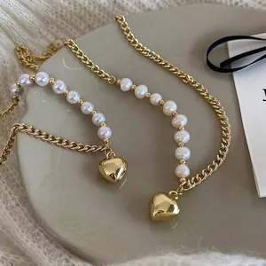 Detailed macro view of French style pearl chain necklaces with gold heart-shaped pendants