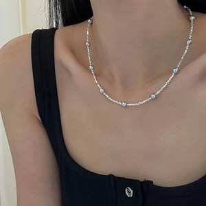 Gros plan sur le collier en argent S925 avec perles grises porté par le mannequin