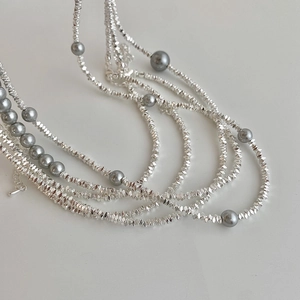 Collier multicouche avec perles grises et argentées facettées au design minimaliste