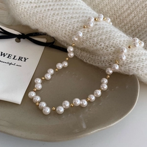 Elegant French vintage pearl necklace with gold metal beads on ceramic dish