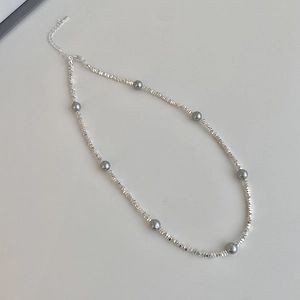 Détail du collier de perles argentées et grises avec fermoir mousqueton et chaînette
