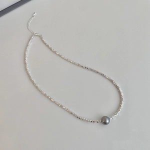 Gros plan du collier de perles grises avec perles argentées facettées et fermoir réglable