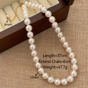 Detail of round pearl necklace showing 6mm and 10mm beads with gold clasp and extension