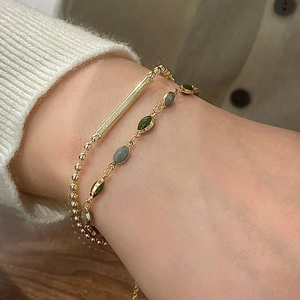 French vintage double-layered gold bracelet with green stones on a model wrist