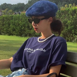 French style layered white pearl necklace worn with a blue beret and casual outfit