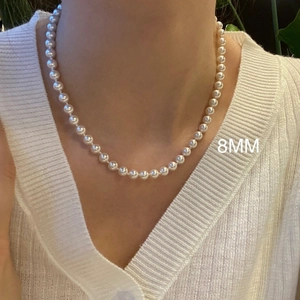 Elegant 8mm white pearl necklace shown on a model for a classic French style look