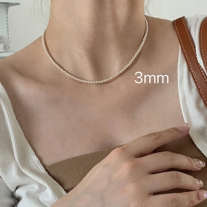 Close-up of a 3mm fine white pearl choker necklace worn by a model for a minimalist look