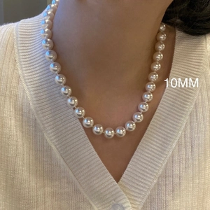 Elegant 10mm round pearl necklace for women styled with a chic white knit sweater
