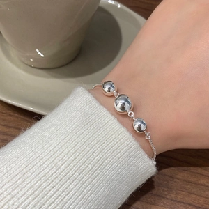Macro view of French retro bracelet featuring three polished silver spheres on a fine chain