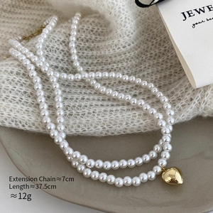 Collana di perle a doppio strato con pendente a cuore dorato e dettaglio catena estensibile