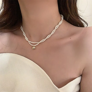 Collana di perle a due strati con ciondolo a cuore in oro lucido su modella donna