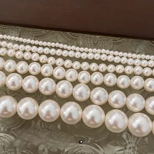 Macro shot of various pearl sizes with creamy luster on a vintage glass surface