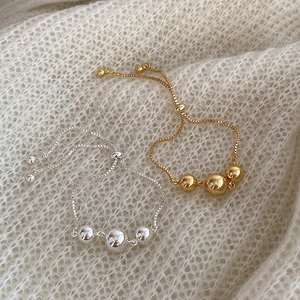 French vintage gold and silver adjustable ball bead bracelets on white knit background