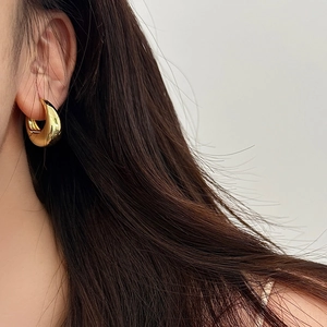 Orecchini huggie ovali geometrici in oro lucido per donna in stile moderno e minimalista