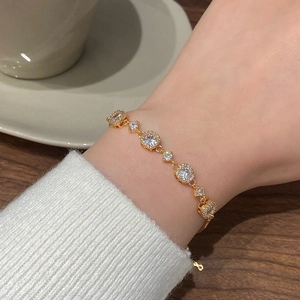 Detail of adjustable gold bracelet with sparkling zircon stones worn on wrist