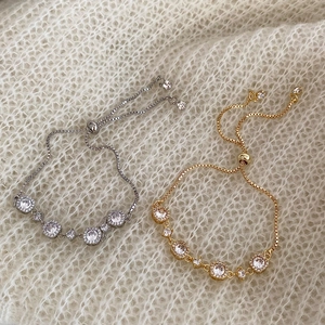 Macro shot of adjustable gold and silver bracelets with sparkling cubic zirconia stones