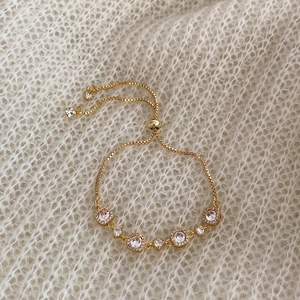 Detail of adjustable gold-plated box chain bracelet with sparkling zircon stones