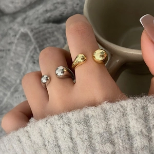 Minimalist adjustable sphere rings in gold and silver finish on model hand
