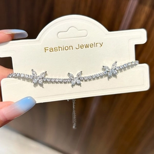 Detailed shot of silver butterfly tennis bracelet with zircon accents and lobster clasp