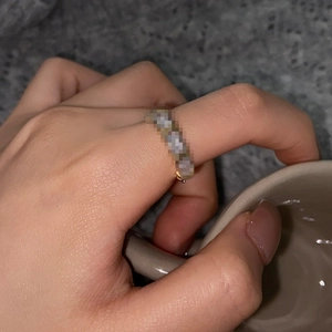 Close-up of golden crossover sparkling ring worn on hand in a lifestyle setting