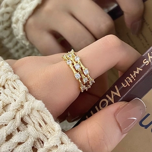 Detail of three-layer gold bamboo rings with micro-paved zircons and textured finish