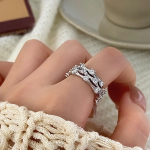 Close-up of three-layer silver ring with sparkling zircon stones on a model hand