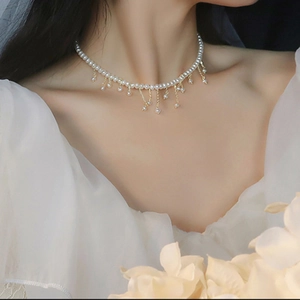 Gros plan d'un collier de perles d'eau douce baroques à pompons sur le cou d'un modèle