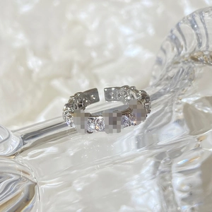 Macro shot of silver adjustable ring with pavé-set zircons on wave glass base