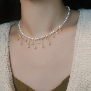 Collier de perles d'eau douce vintage avec pendentifs glands dorés porté sur modèle