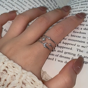 Detailed view of triple-layered star and moon ring with pavé set crystals on a hand