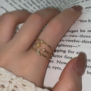 Detailed close-up of a three-layer gold star and moon ring with pavé-set zircons on hand