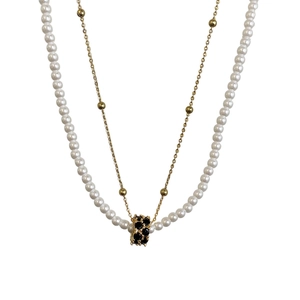 Collier double rang avec perles blanches, chaîne dorée et pendentif cylindre en zircon noir